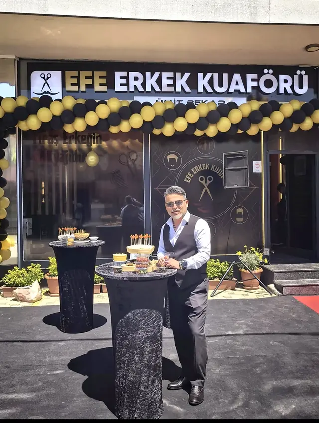 Ümit Bekar, Efe Erkek Kuaförü'nün balonlarla süslenmiş açılış gününde dükkânın önünde